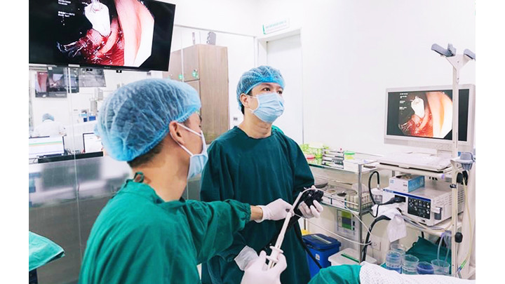 Các bác sĩ thực hiện mổ nội soi cho người bệnh. Ảnh: THANH HUYỀN