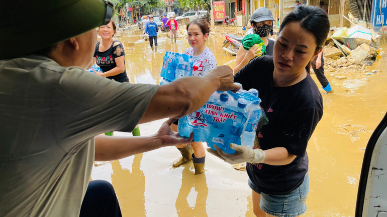 Bệnh viện Sản Nhi Yên Bái dùng xe cứu thương vào vùng ngập trao đồ uống cho dân.(Ảnh: THANH SƠN)