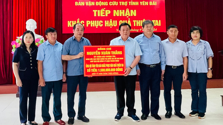 Đồng chí Nguyễn Xuân Thắng, Ủy viên Bộ Chính trị, Giám đốc Học viện Chính trị quốc gia Hồ Chí Minh trao 1,5 tỷ đồng khắc phục hậu quả thiên tai. (Ảnh: THANH SƠN)