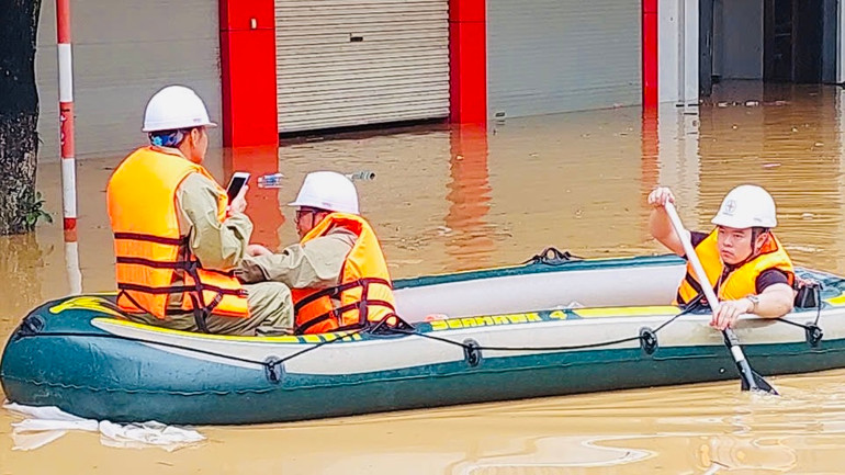 Giữa lúc lũ dâng cao, nhân viên điện lực Yên Bái tham gia cứu hộ tại phường Nguyễn Thái Học, thành phố Yên Bái. (Ảnh: THANH SƠN)