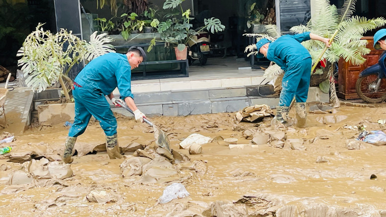 Dân quân thành phố tham gia vệ sinh môi trường. (Ảnh: THANH SƠN)