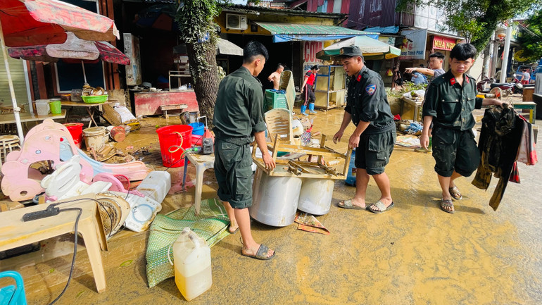 Chiến sĩ Cảnh sát Cơ động tham gia hỗ trợ nhân dân thành phố dọn vệ sinh môi trường tại phường Nguyễn Thái Học. (Ảnh: THANH SƠN)