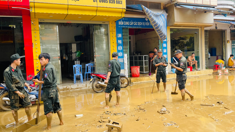 Chiến sĩ đơn vị Cảnh sát cơ động tham gia vệ sinh môi trường. (Ảnh: THANH SƠN)