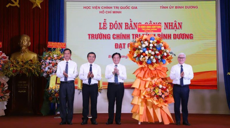 Bí thư Tỉnh ủy Bình Dương Nguyễn Văn Lợi (bên phải) tặng lẵng hoa chúc mừng Trường Chính trị tỉnh Bình Dương đạt chuẩn mức 1.