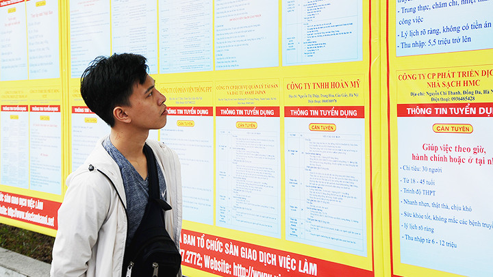 Người lao động tìm hiểu thông tin doanh nghiệp tuyển dụng. Ảnh: SONG ANH