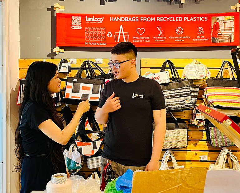 Chị Hằng chia sẻ kinh nghiệm công việc với Thịnh, cậu nhân viên khiếm thính ham học hỏi.