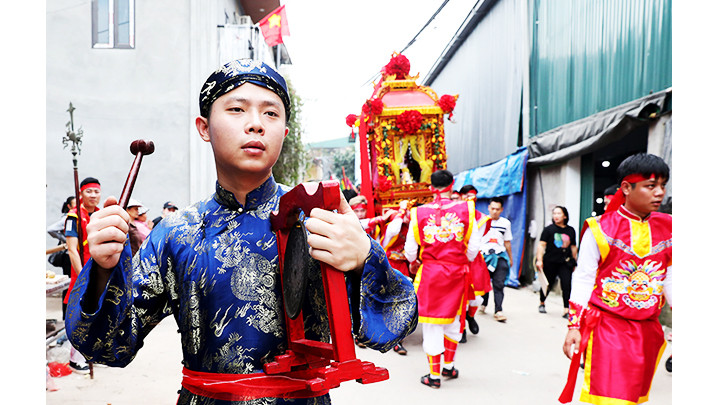 Các trai làng mặc trang phục xưa tham gia đoàn rước kiệu.