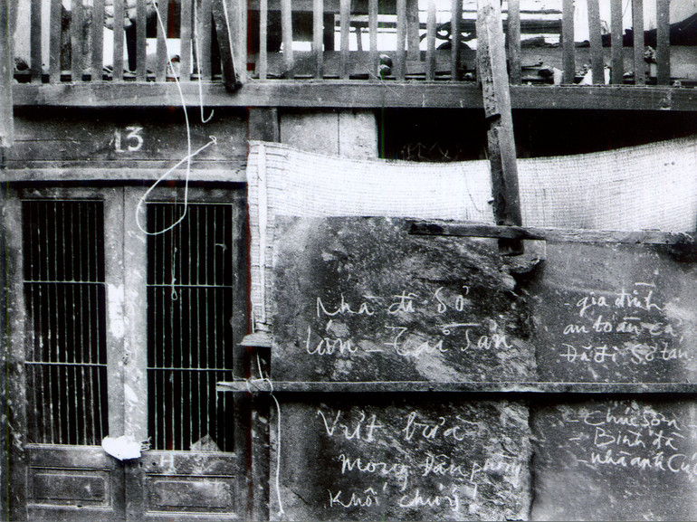 Cửa ngôi nhà số 13 Ngõ Chợ Khâm Thiên. Bức ảnh được đặt tên “Lòng tin trong hoạn nạn” (năm 2015 được Liên hiệp các Hội Liên hiệp Văn học Nghệ thuật Việt Nam tặng giải thưởng về đề tài Cách mạng và kháng chiến từ năm1930 đến năm 1975).