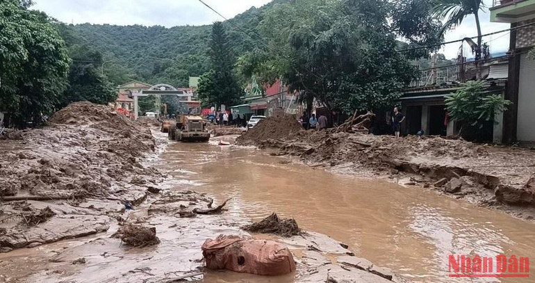 Lực lượng chức năng khẩn trương xử lý bùn đất để thống tuyến giao thông. (Ảnh: Tiến Đông)