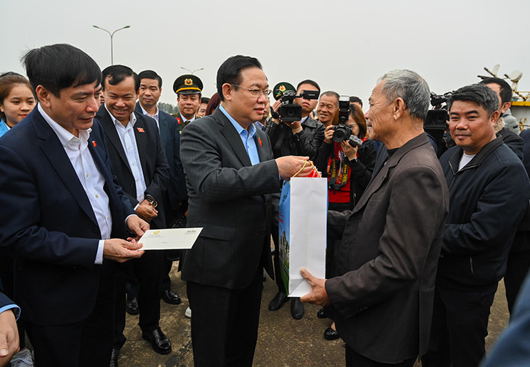 Chủ tịch Quốc hội Vương Đình Huệ tặng quà Tết cho ngư dân tại Khu neo đậu tàu thuyền Cửa Phú, xã Bảo Ninh, thành phố Đồng Hới. (Ảnh Duy Linh)