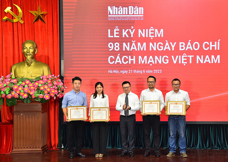 Tổng Biên tập Báo Nhân Dân Lê Quốc Minh trao bằng khen của Tổng Biên tập tặng đại diện các tập thể, cá nhân có thành tích xuất sắc tại buổi lễ mít-tinh.