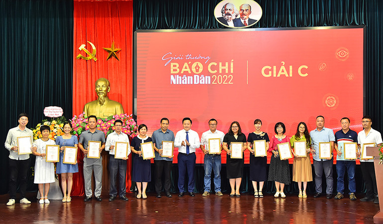 Phó Tổng Biên tập Báo Nhân Dân Phan Văn Hùng trao giải C tặng các tác giả, đại diện nhóm tác giả đạt Giải Báo chí Nhân Dân năm 2022.