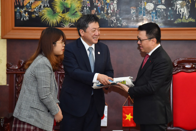 Ông Shimizu Akira, Trưởng đại diện JICA tại Việt Nam nhiệm kỳ từ 3/2020-3/2023 trao món quà là những chiếc túi với hình ảnh các dự án JICA thực hiện tại Việt Nam tặng Tổng Biên tập Báo Nhân Dân Lê Quốc Minh.