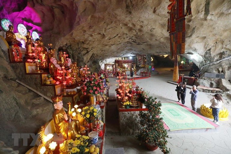 Du khách lễ Tam Bảo - nơi thờ Phật trong chùa Tam Thanh giữa không gian tâm linh huyền ảo của động núi đá. (Ảnh: Anh Tuấn/TTXVN)
