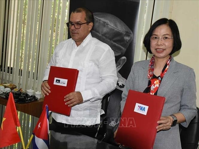 Tổng Giám đốc Thông tấn xã Việt Nam Vũ Việt Trang và Chủ tịch Prensa Latina Luis Enrique González Acosta ký thỏa thuận hợp tác mới. (Ảnh: Mai Phương/Pv TTXVN tại La Habana)