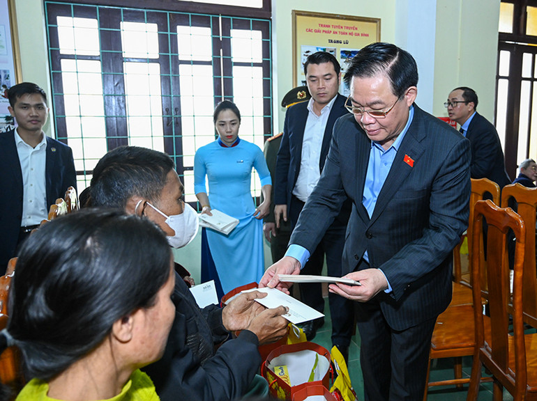 Chủ tịch Quốc hội Vương Đình Huệ tặng quà cho gia đình chính sách tại huyện Quảng Ninh. (Ảnh Duy Linh)