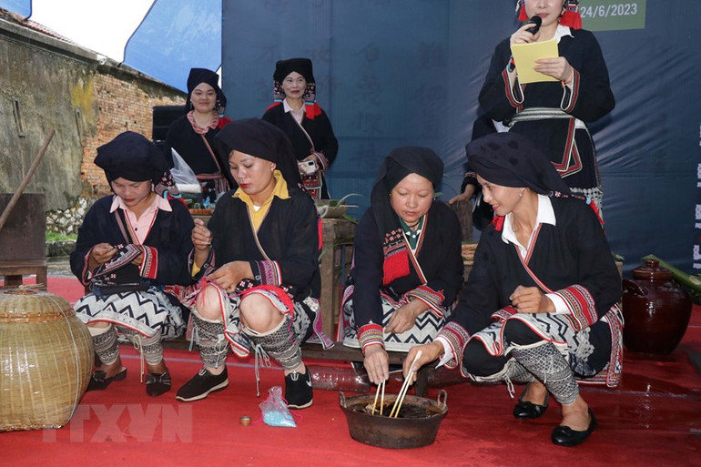 Các nghệ nhân người Dao trình diễn trang trí hoa văn trên vải và nhuộm vải. (Ảnh: Hữu Quyết/TTXVN)