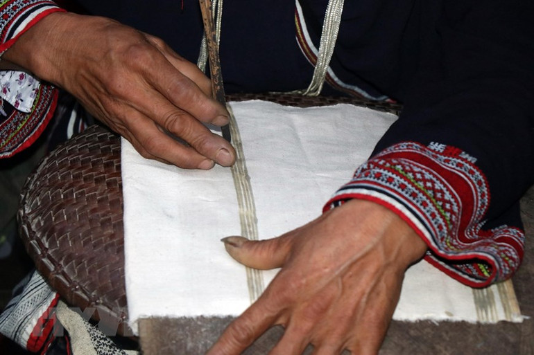 Sản phẩm hoa văn được in bằng sáp ong do nghệ nhân người Dao thực hiện. (Ảnh: Hữu Quyết/TTXVN)