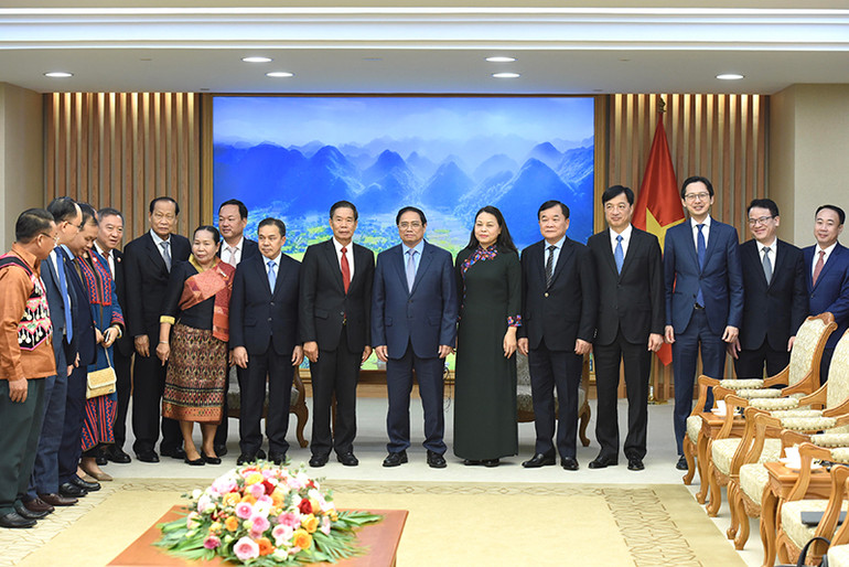 Thủ tướng Phạm Minh Chính và đồng chí Sinlavong Khoutphaythoune, Chủ tịch Ủy ban Trung ương Mặt trận Lào xây dựng đất nước chụp ảnh chung với các thành viên của hai đoàn.