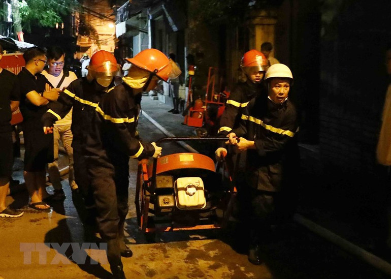 Lực lượng phòng cháy chữa cháy và cứu nạn cứu hộ đưa thiết bị chuyên dụng tiếp cận đám cháy. (Ảnh: Phạm Kiên/TTXVN)