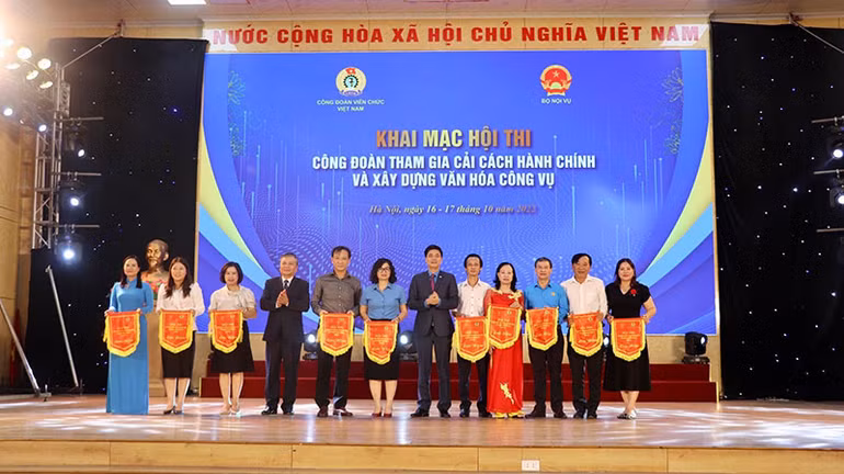 Đồng chí Ngọ Duy Hiểu, Phó Chủ tịch Tổng Liên đoàn Lao động Việt Nam, Chủ tịch Công đoàn Viên chức Việt Nam trao cờ lưu niệm cho các đơn vị tham gia Hội thi “Công đoàn tham gia cải cách hành chính và xây dựng văn hóa công vụ”.