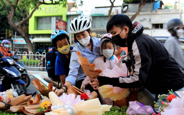Phụ huynh cùng học sinh đi học sớm chọn những bông hoa tươi nhất để gửi tặng các thầy cô giáo.