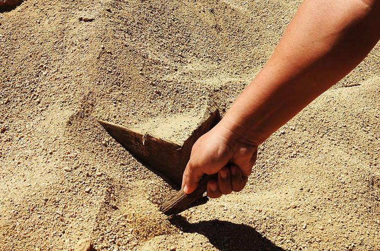 Một tấm gỗ lớn vẫn đang còn bị chôn trong cát.