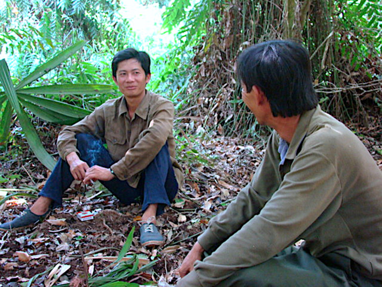 Camera chuyên dụng lắp đặt trong rừng ghi lại hình ảnh kỹ sư Truyền và một thợ rừng đi tìm dấu vết rắn khổng lồ.