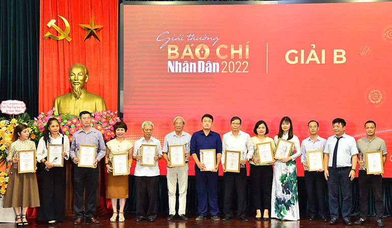 Phó Tổng Biên tập Báo Nhân Dân Quế Đình Nguyên trao giải B tặng các tác giả, đại diện nhóm tác giả đạt Giải Báo chí Nhân Dân năm 2022.