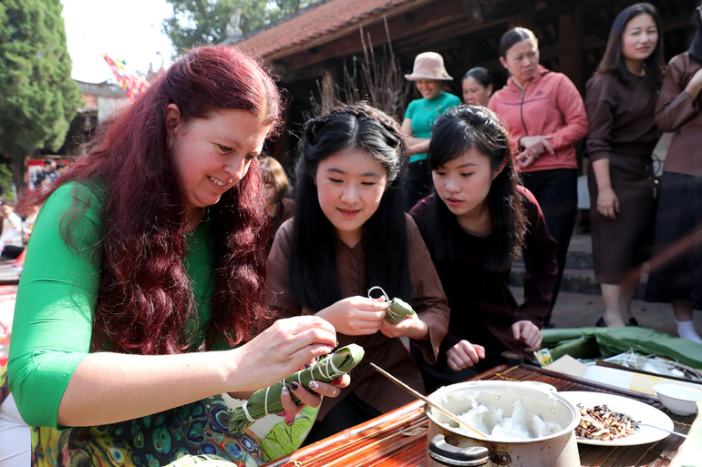 Đại biểu ngoại tham gia trải nghiệm gói bánh tẻ.