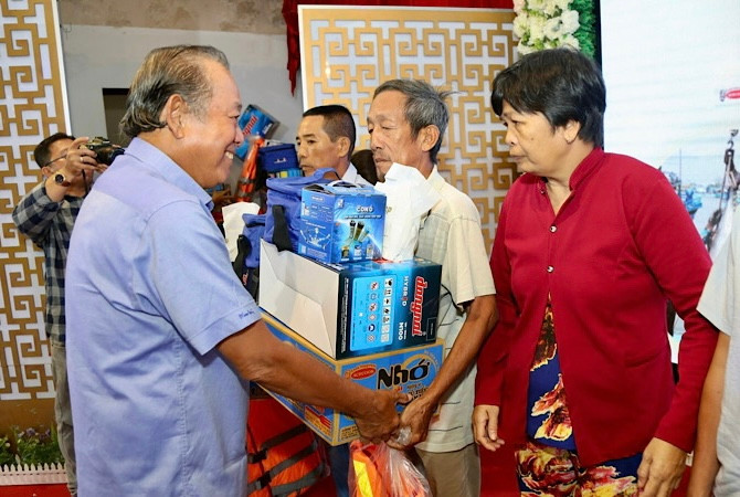 Nguyên Phó Thủ tướng Thường trực Chính phủ Trương Hòa Bình tặng quà cho ngư dân Bạc Liêu.