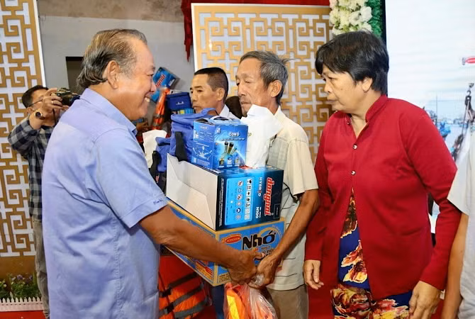 Nguyên Phó Thủ tướng Thường trực Chính phủ Trương Hòa Bình tặng quà cho ngư dân Bạc Liêu.