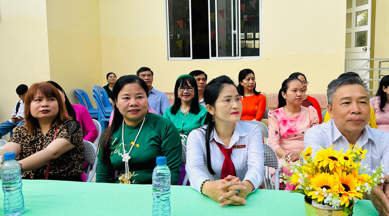 Các đại biểu và các nhà tài trợ giúp các em học sinh hoàn cảnh khó khăn. (Ảnh: TRỌNG DUY)