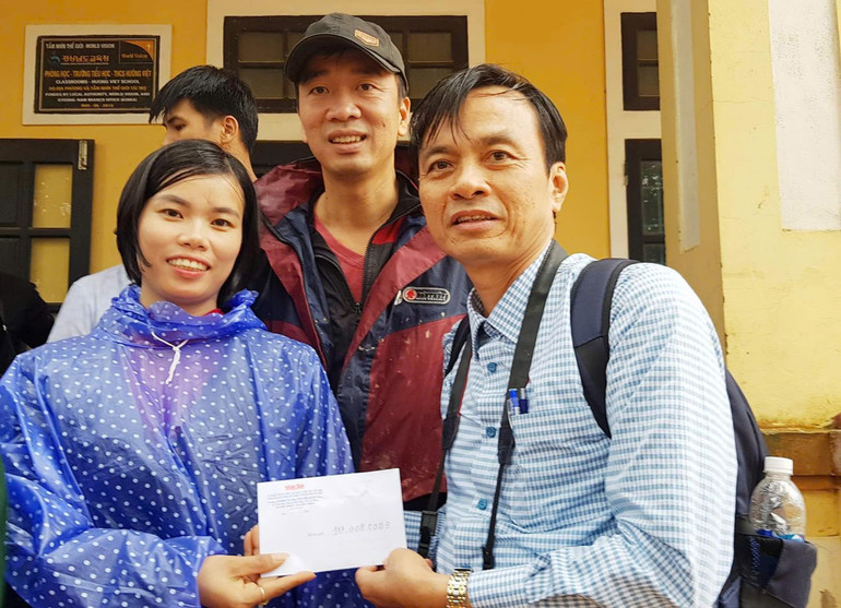 Nhà báo Lâm Quang Huy và đồng nghiệp ủng hộ tiền mặt cho Trường TH-THCS Hướng Việt ngày lũ quét năm 2020.