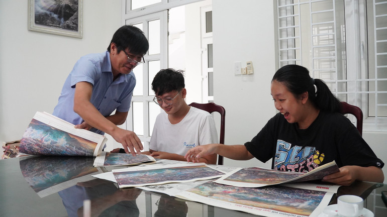 Các bạn trẻ háo hức khám phá bản tranh đặc biệt do Báo Nhân Dân trao tặng.