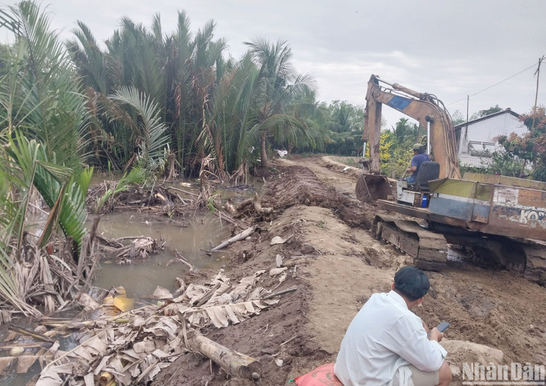Phương tiện cơ giới đang gia cố đoạn đê bao xung yếu tại xã Ninh Thới, huyện Cầu Kè.
