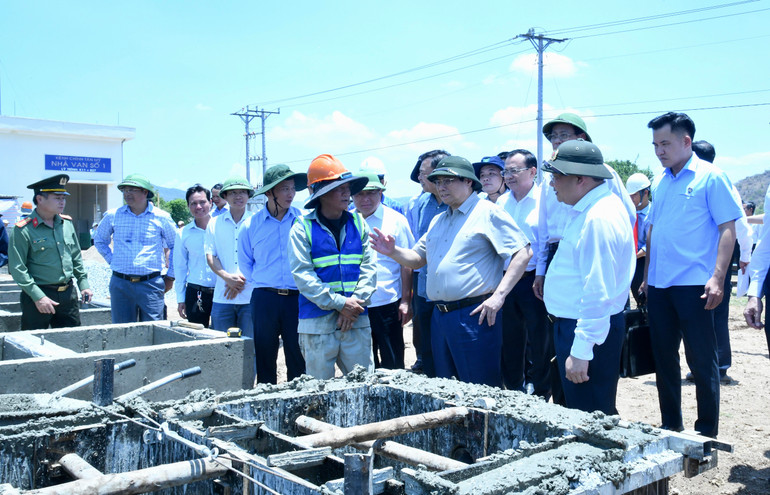 Thủ tướng Phạm Minh Chính nói chuyện với công nhân đang thi công cấu kiện bê tông tại dự án Hệ thống thủy lợi Tân Mỹ.