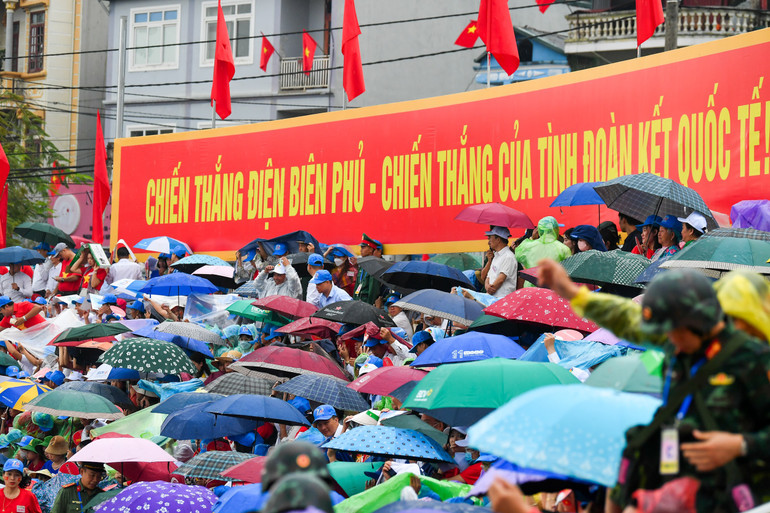 Người dân đội mưa chờ xem lễ diễu binh.