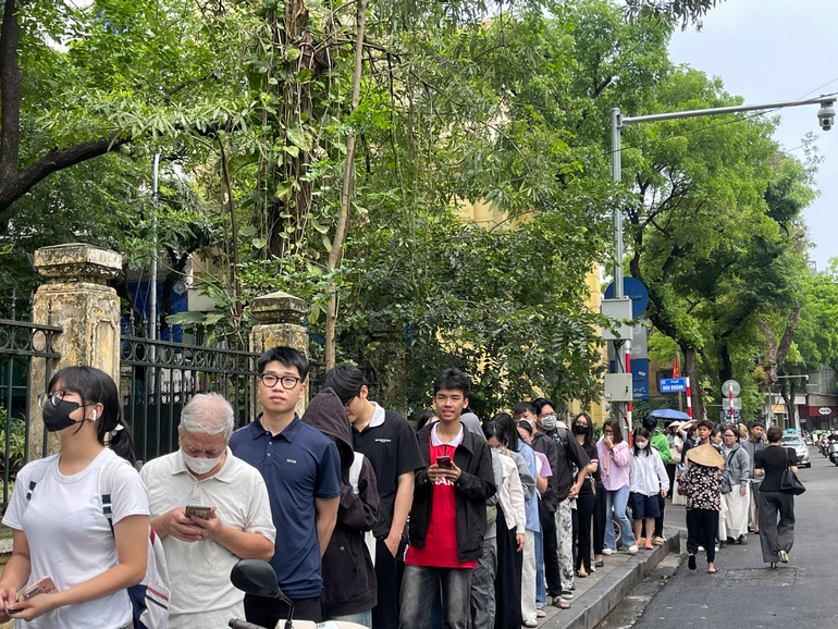 Nhiều bậc cha, mẹ xếp hàng để chờ nhận tờ báo đặc biệt mang về cho con trải nghiệm.