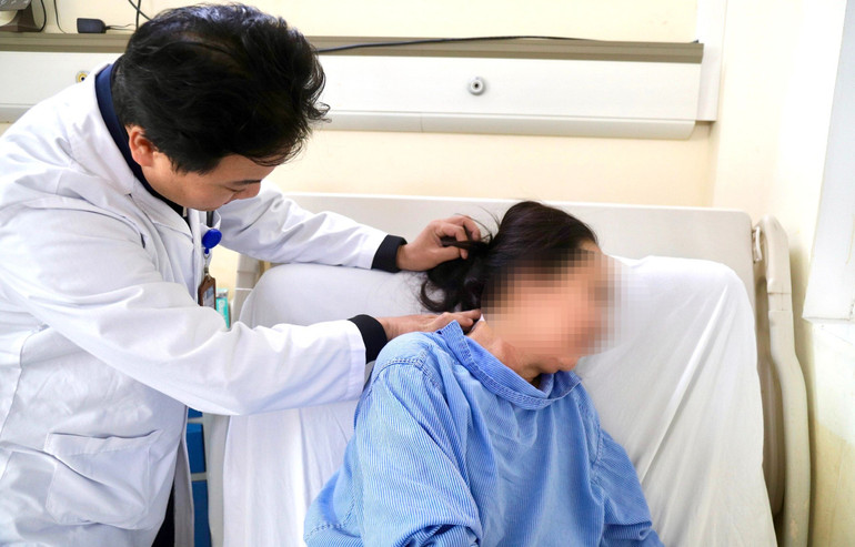 Bác sĩ kiểm tra vết mổ sau khi được phẫu thuật loại bỏ khối u.