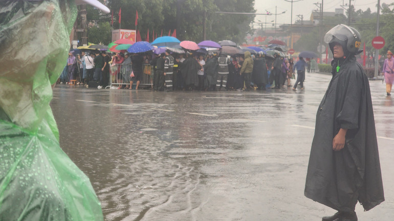 Lực lượng chức năng căng mình làm việc dưới mưa.