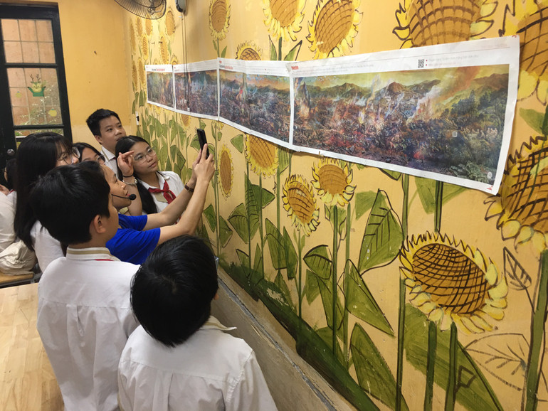 Thầy Hiệu trưởng Trường THCS Thái Thịnh, Hà Nội dán tranh panorama ở các lớp cho học sinh xem tranh.