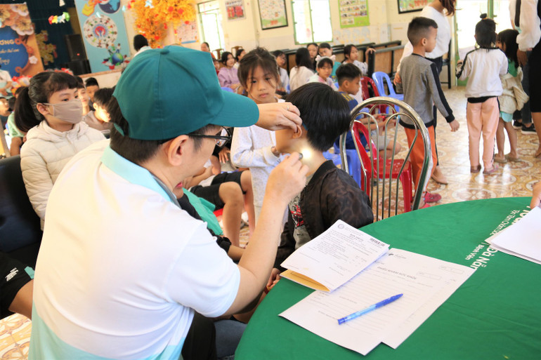 Các bác sĩ khám sức khoẻ cho các trẻ em mồ côi.