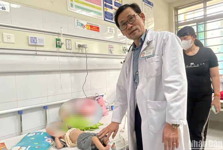 Tiến sĩ, bác sĩ Đỗ Thiện Hải khám cho bệnh nhi mắc sởi.