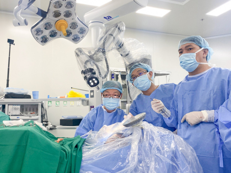 Bác sĩ Tấn Sĩ (người ngồi) và cộng sự trong ca mổ não tỉnh thức cho người bệnh bằng Robot Modus V Synaptive.