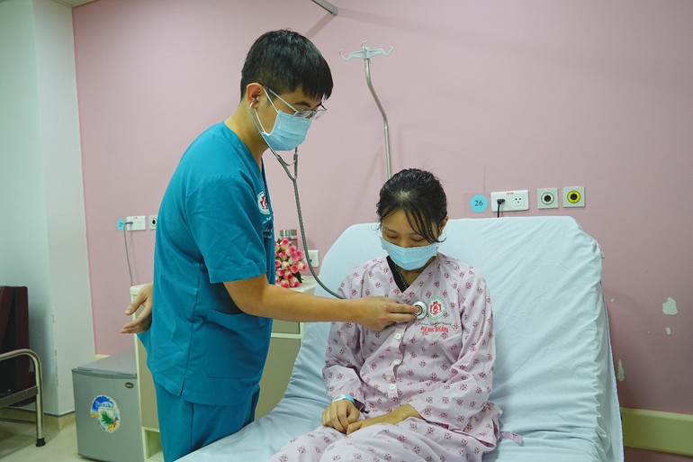 Bác sĩ thăm khám cho em T. trước khi em ra viện.