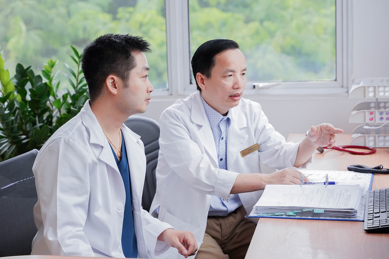 Tiến sĩ, bác sĩ Đặng Quang Huy và Thạc sĩ, bác sĩ Lê Văn Bình trao đổi về tình hình bệnh nhân sau cuộc đại phẫu.