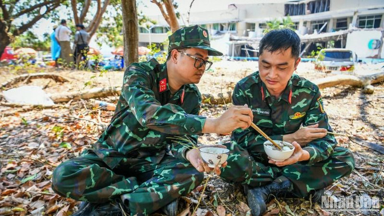 Lực lượng cứu nạn, cứu hộ Quân đội nhân dân Việt Nam tranh thủ ăn cơm để chuẩn bị vào ca làm việc buổi chiều. (Ảnh: THÀNH ĐẠT) Lực lượng cứu nạn, cứu hộ Quân đội nhân dân Việt Nam tranh thủ ăn cơm để chuẩn bị vào ca làm việc buổi chiều. (Ảnh: THÀNH ĐẠT)