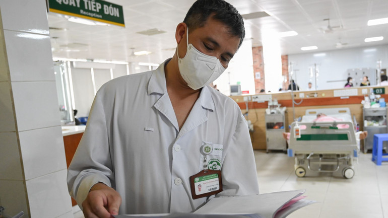 Bác sĩ Nguyễn Trung Nguyên xem hồ sơ bệnh án của bệnh nhân ngộ độc rượu.