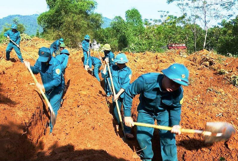 Lực lượng dân quân tìm kiếm hài cốt liệt sĩ.